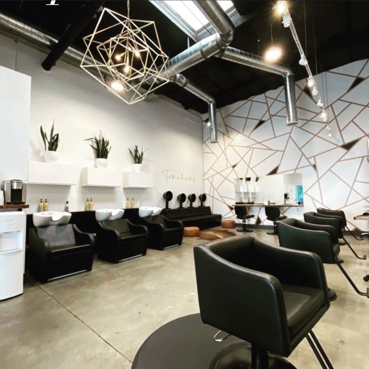 Modern salon interior with geometric wall art and styling stations