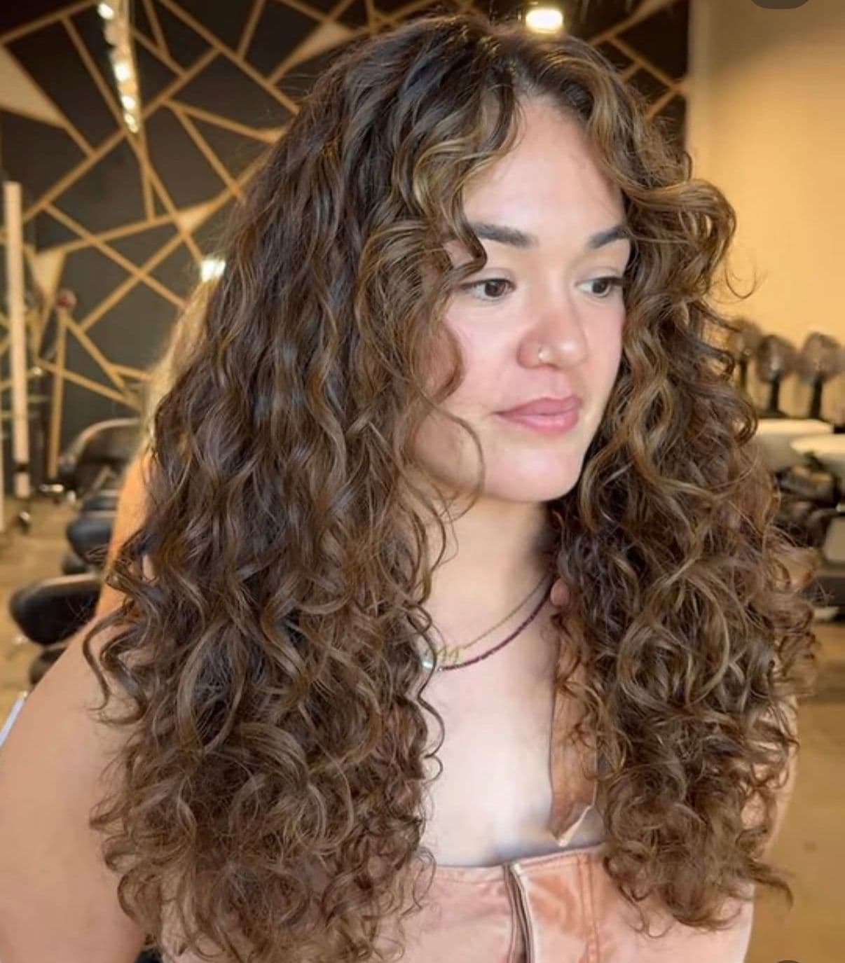 Long defined brunette curls with golden highlights