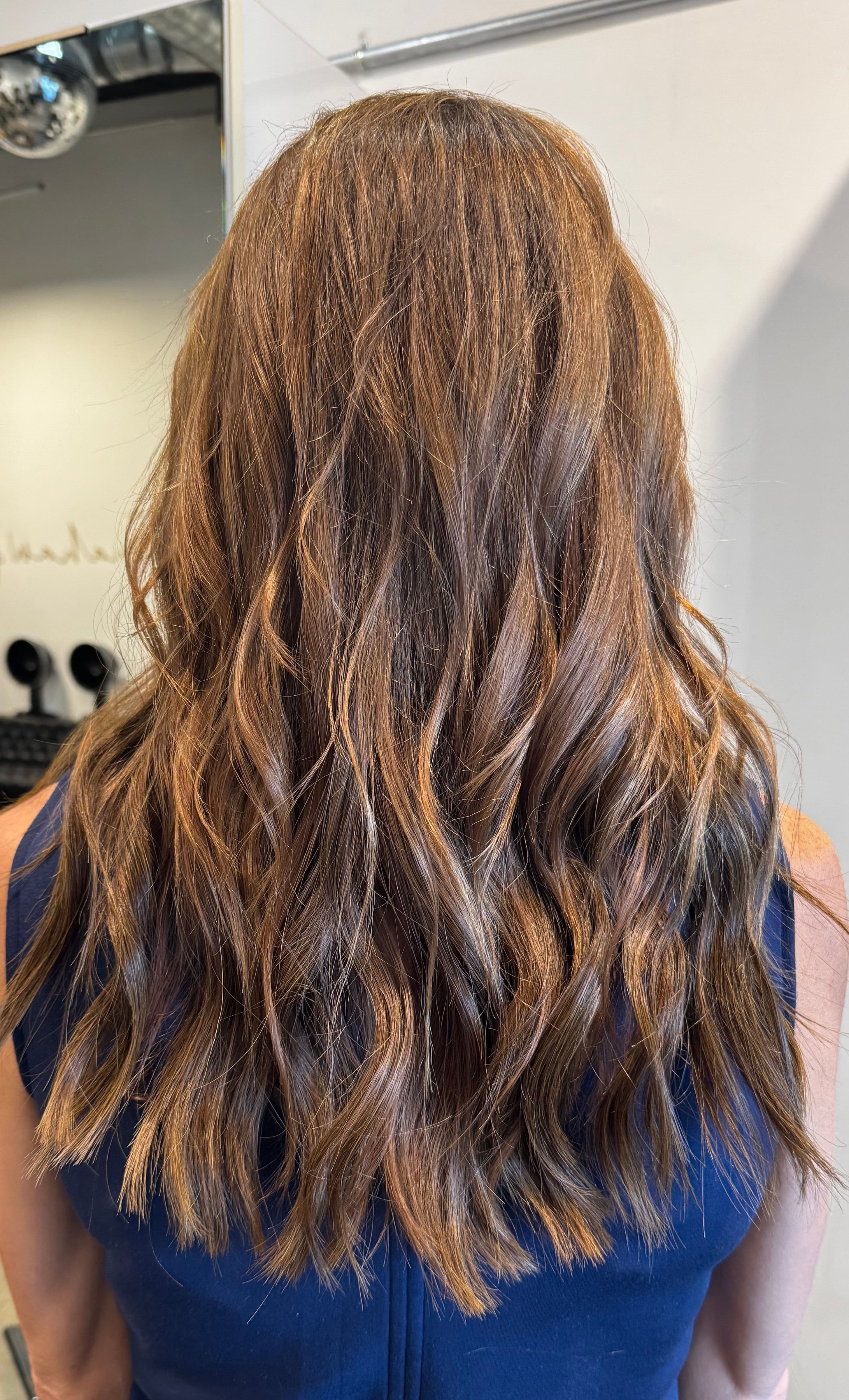 Long brunette hair with subtle balayage and soft waves