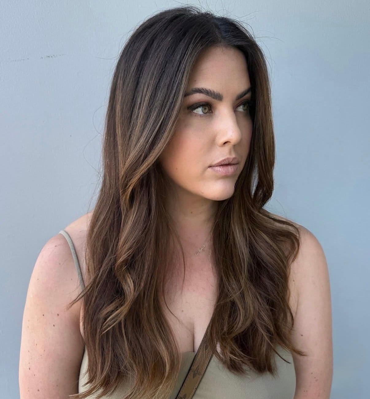 Long brunette hair with dimensional highlights and soft waves