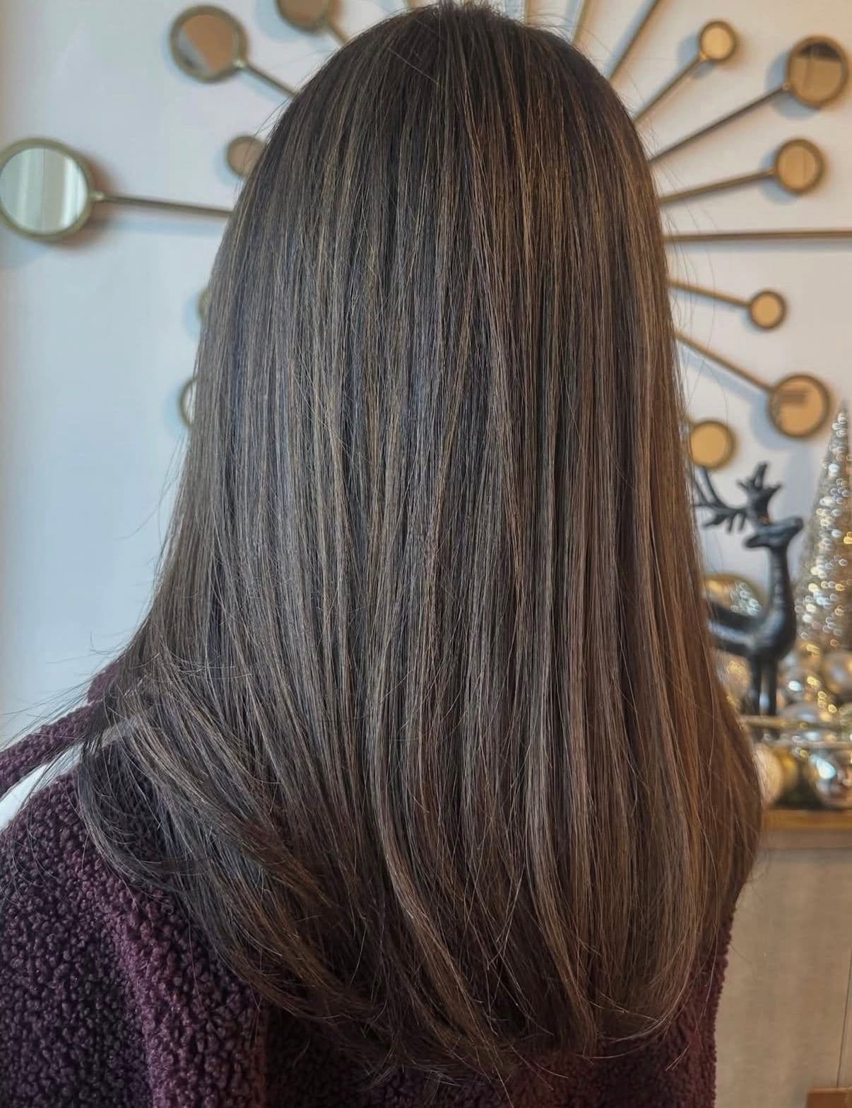 Smooth brunette hair with subtle highlights and sleek blow-out
